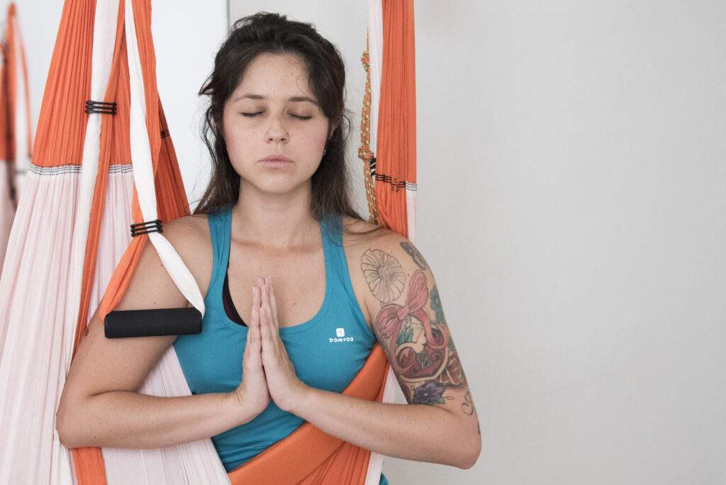 postura de yoga aéreo con columpio con estribos en formación de yoga aéreo