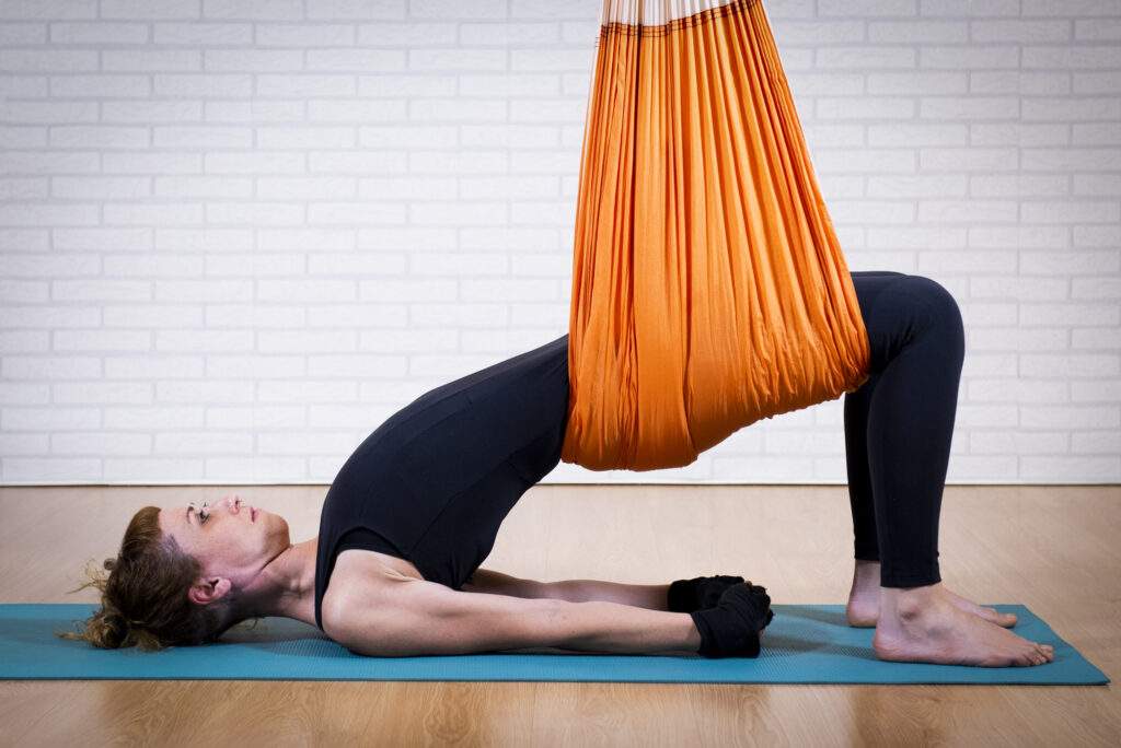 Karanas de yoga aéreo ayurvédico para activar Kapha en columpio
